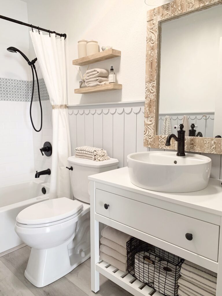 Bathroom with Sherwin Williams Pure White walls and Olympus White Scalloped Shiplap trim, black bathroom hardware and wood accents