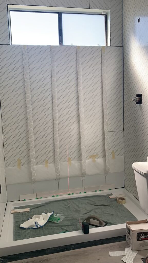 applying Musselbound tile mat and Musselbound seam tape to wall