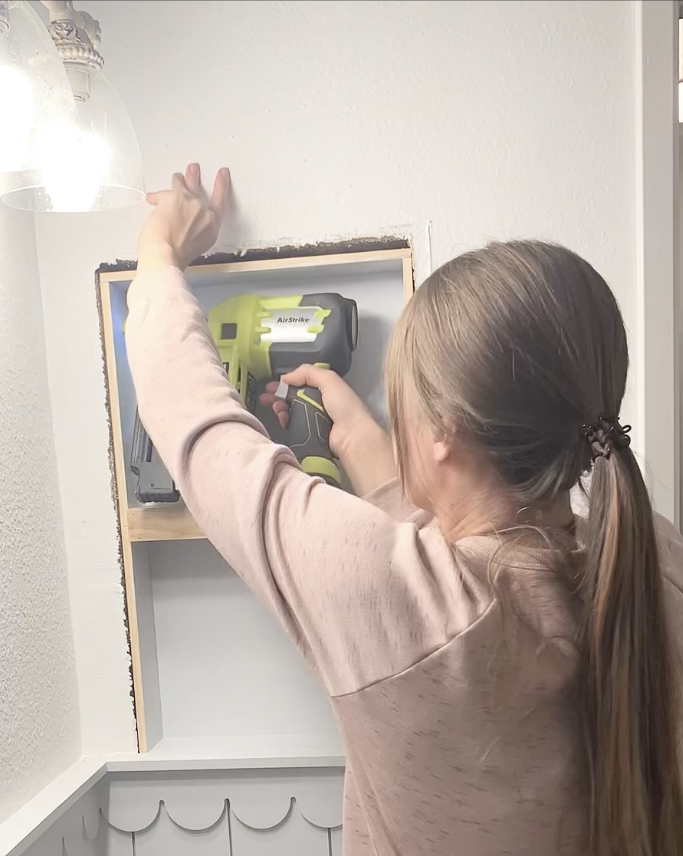 Woman replacing old medicine cabinet with open shelving