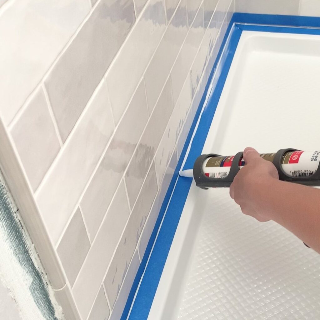 applying silicone between tile and shower pan