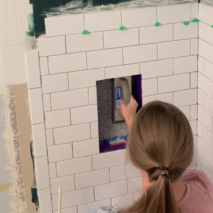 installing mosaic tile in shower niche
