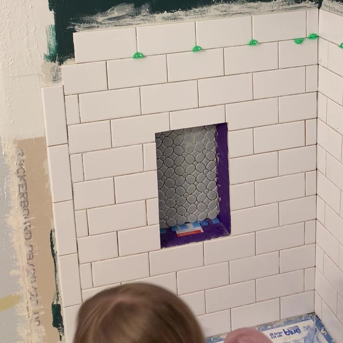 shower niche with mosaic flower tile
