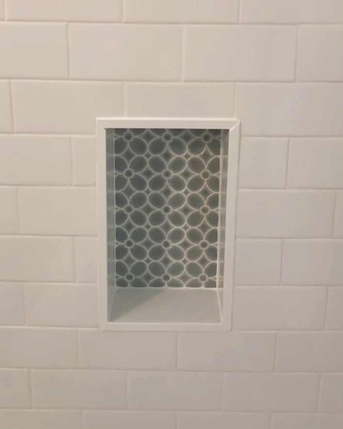 shower niche with mosaic tile in white subway tile shower