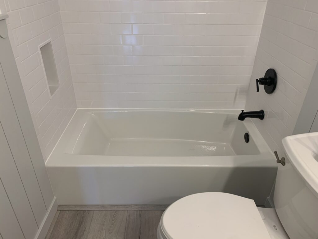 shower niche in white subway tile shower with black fixtures