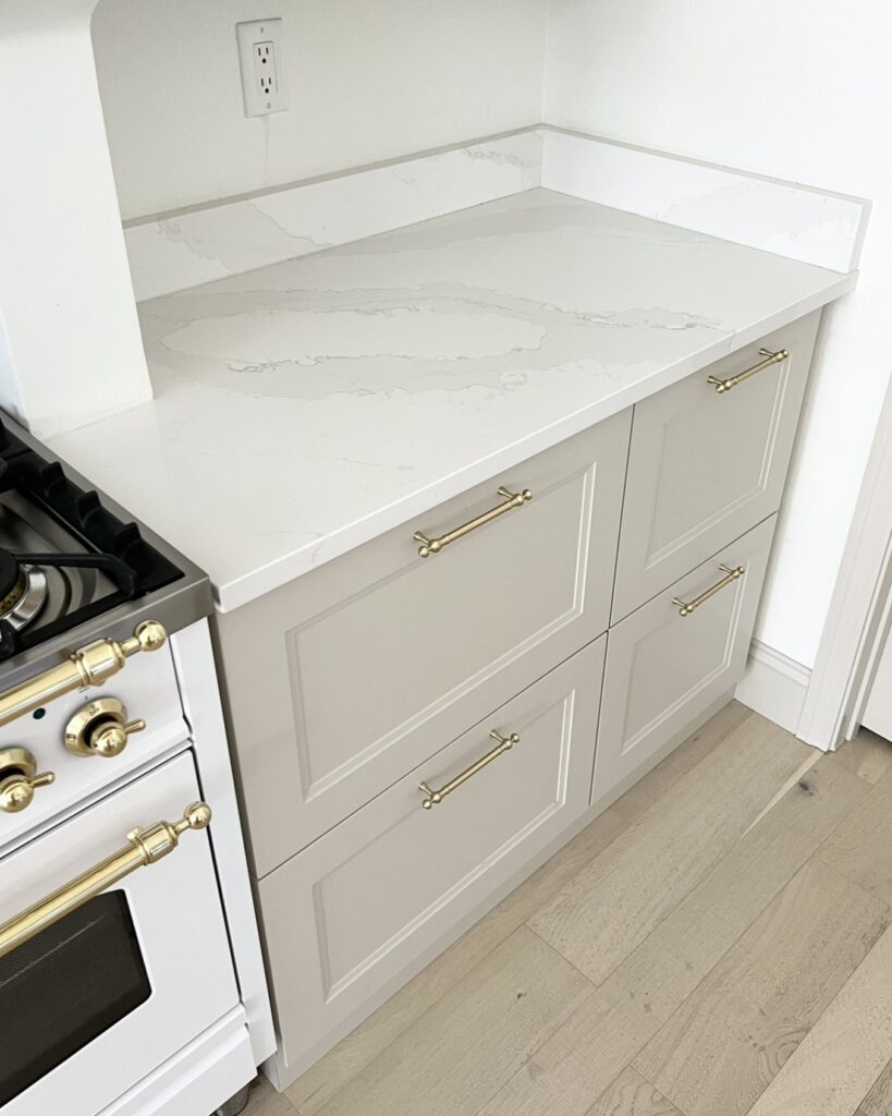Silestone Calacatta Gold with accessible beige cabinets and brass finishes