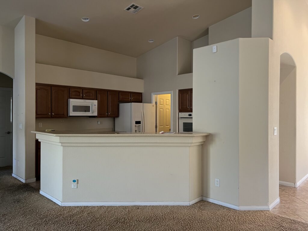 outdated kitchen with arch connecting to the kitchen island