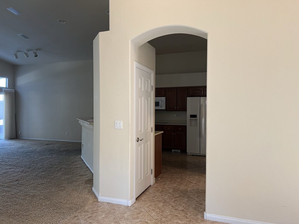 outdated kitchen with arch connecting to the kitchen island