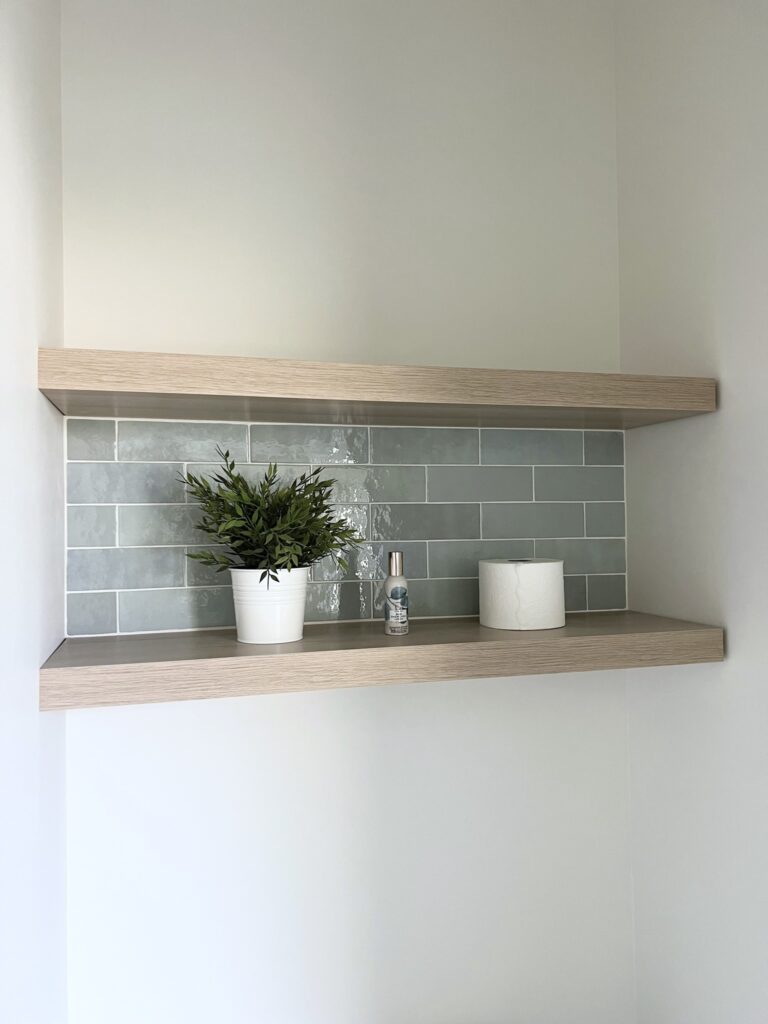 Water closet with Bedrosians Cloe Baby Blue tile and oak floating shelves